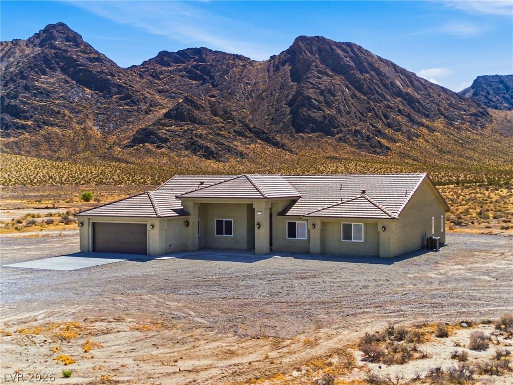 Image 1: A desert-modern residence with a tiled roof sits a