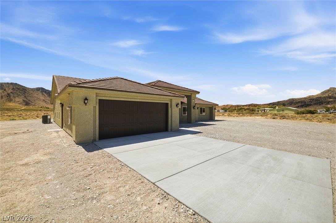 Image 4: A desert oasis with a wide concrete driveway leadi