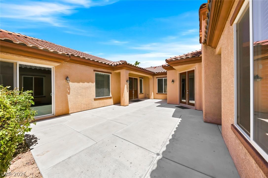 Image 3: A spacious, sun-drenched concrete patio creates a