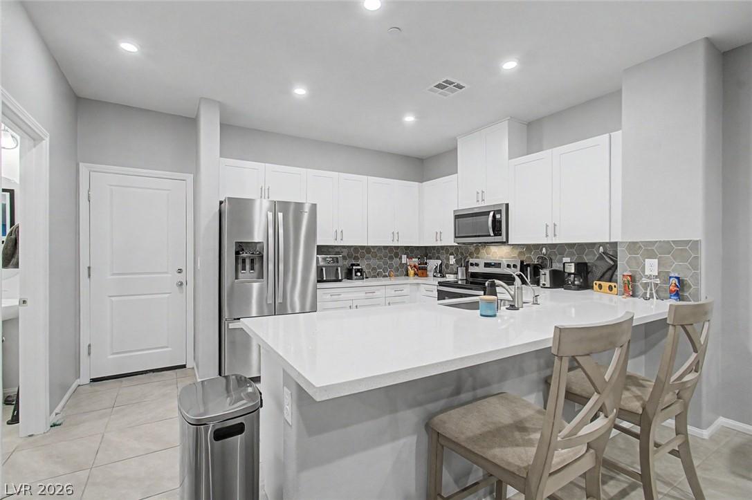 Image 1: A well-lit kitchen with sleek stainless steel appl
