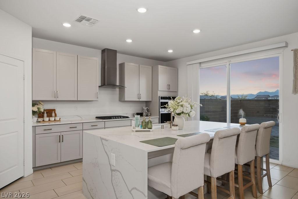 Image 3: Kitchen featuring a kitchen breakfast bar, light s