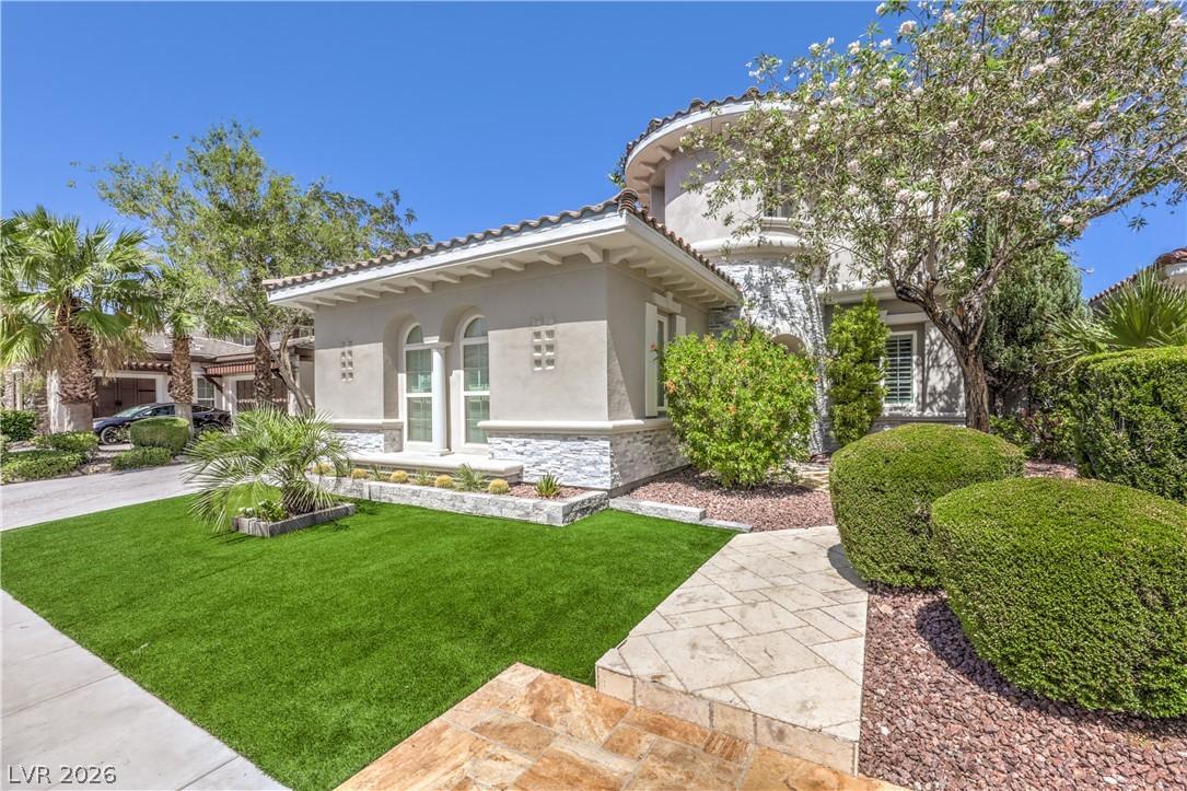 Image 4: A well-manicured front yard with artificial turf a