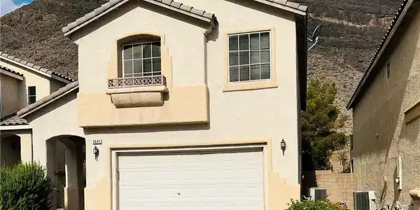 Image 3: A cream-colored stucco residence presents a welcom
