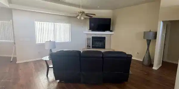 Image 3: This living area showcases rich hardwood flooring,