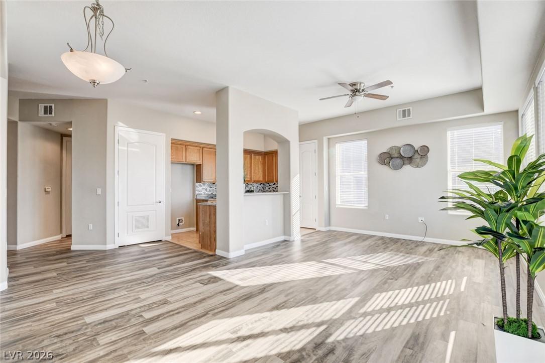 Image 2: Well-lit living area with rich wood-look flooring