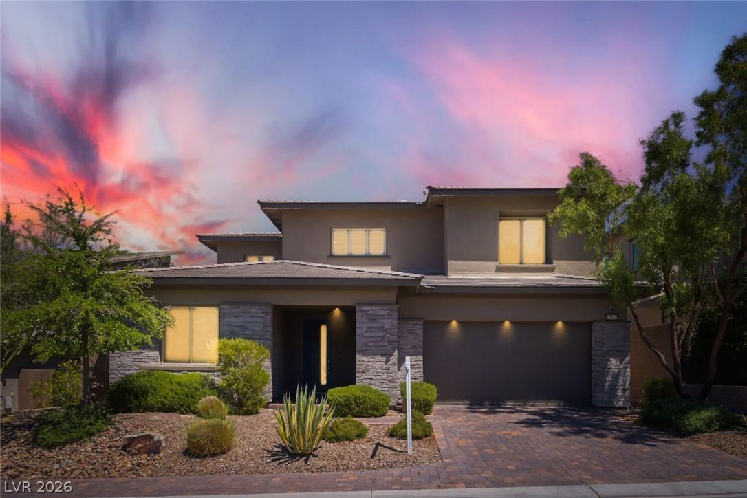 Image 1: A modern facade with stone accents and desert land