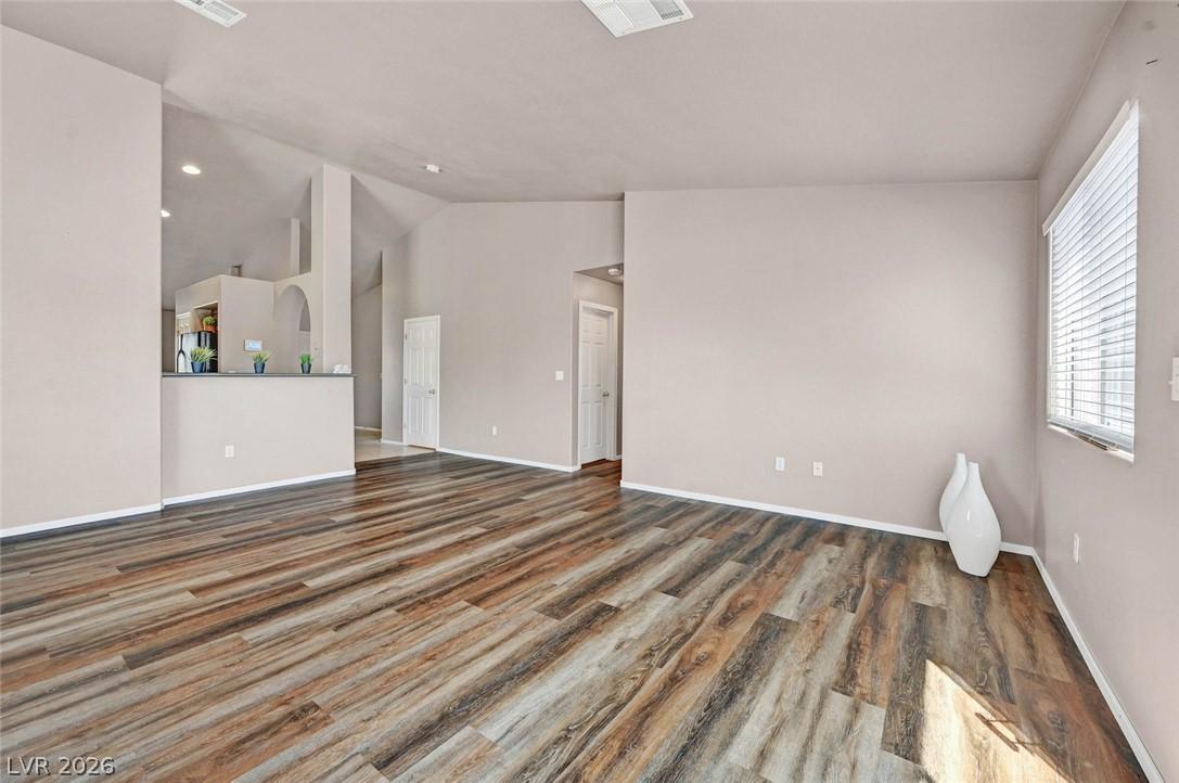 Image 4: A spacious room features durable wood-look floorin
