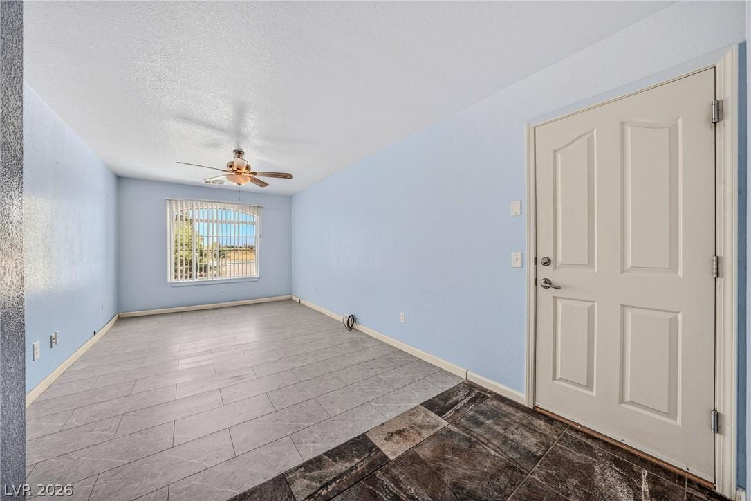 Image 3: A window-filled living area features a ceiling fan