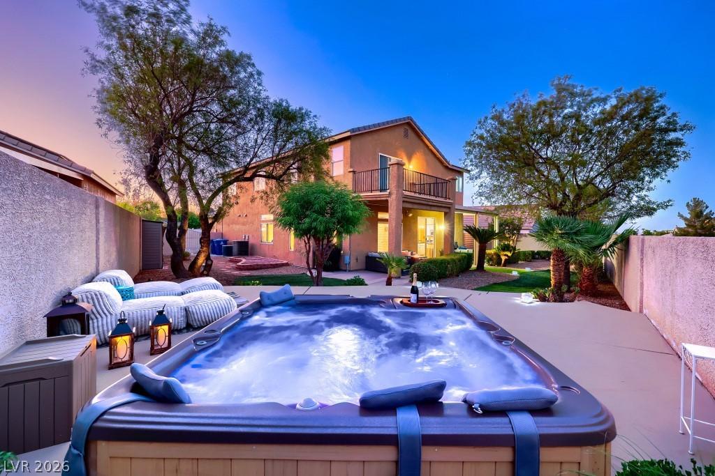 Image 4: An inviting backyard oasis offers a sparkling spa