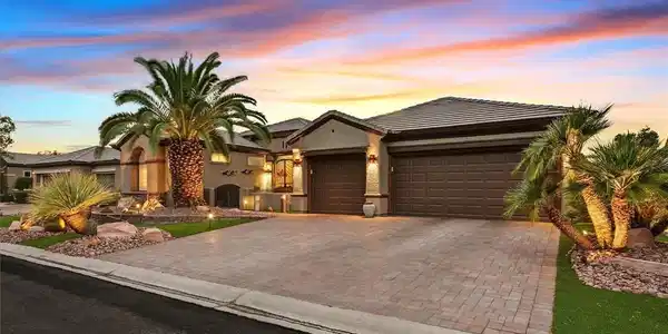 Image 2: Palm trees and manicured stone garden beds frame t