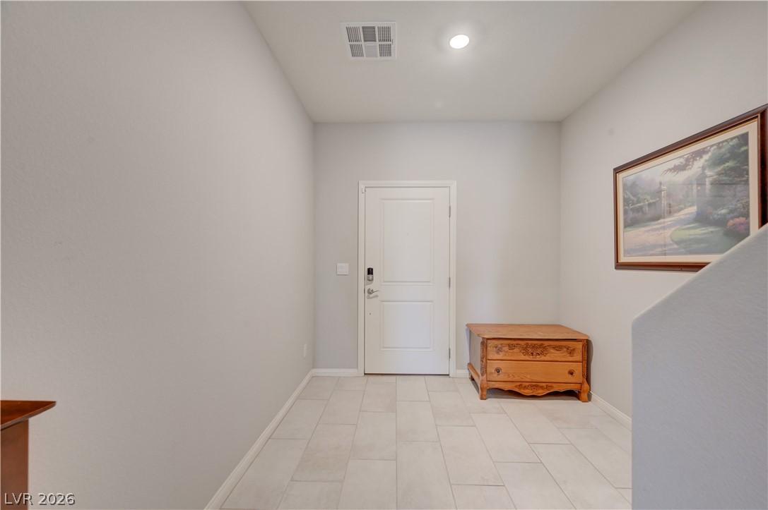 Image 4: A well-lit entry with sleek tile flooring and ampl