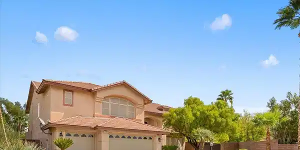 Image 3: An arched window accents the stucco facade of this