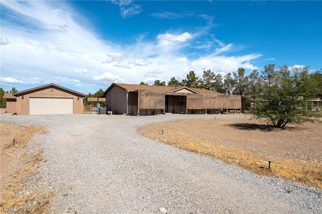 Image 4: A spacious gravel driveway leads to a detached gar