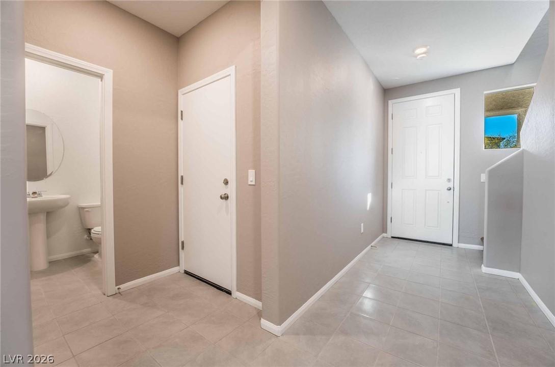 Image 4: A well-lit entry hall with tiled flooring and conv