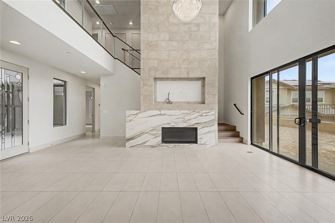 Image 4: A grand living area showcases high ceilings, a con