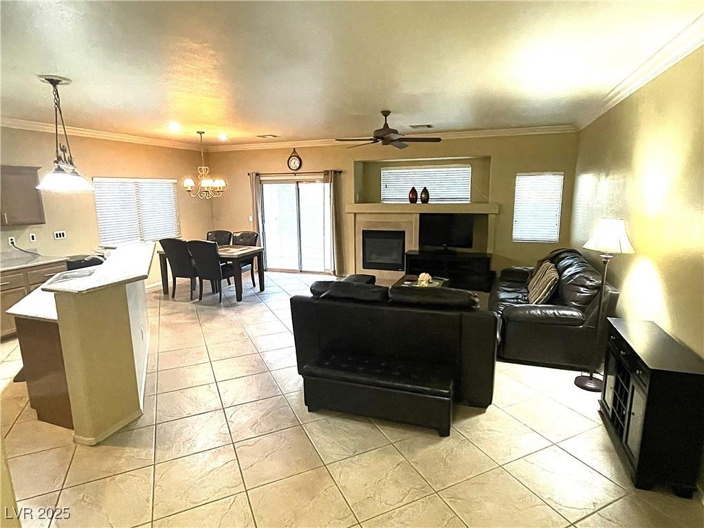 Image 4: Living room featuring crown molding, a chandelier,