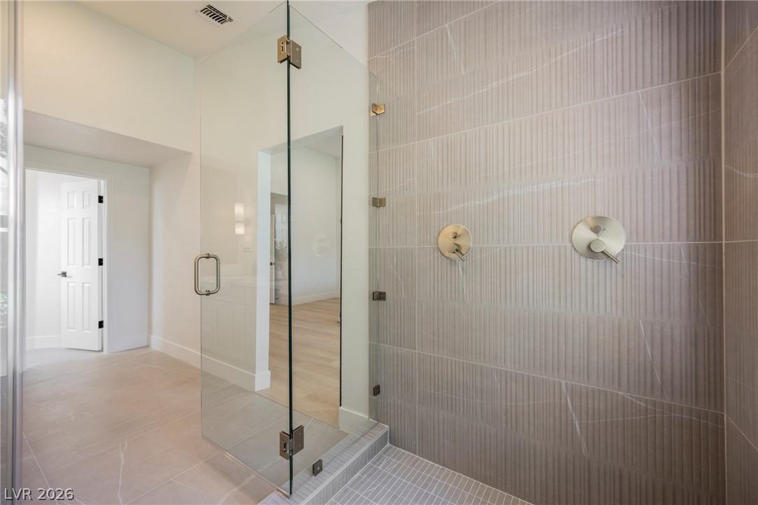Image 3: A pristine glass-enclosed shower showcases modern