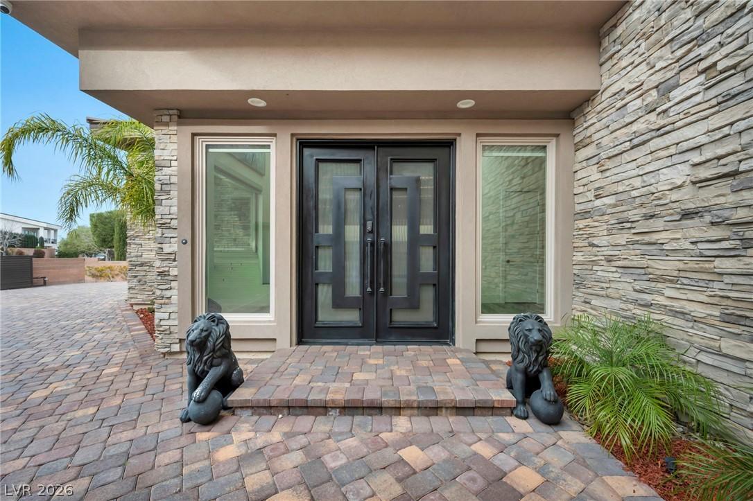 Image 2: Doorway to property featuring stone siding, stucco