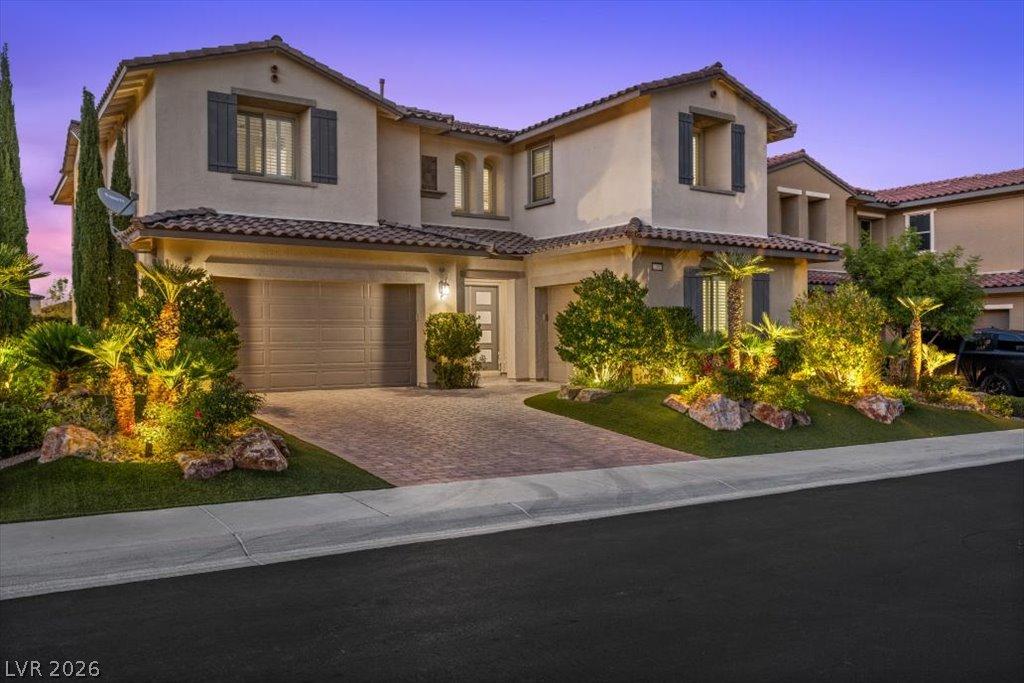 Image 2: Illuminated landscaping highlights the elegant fac