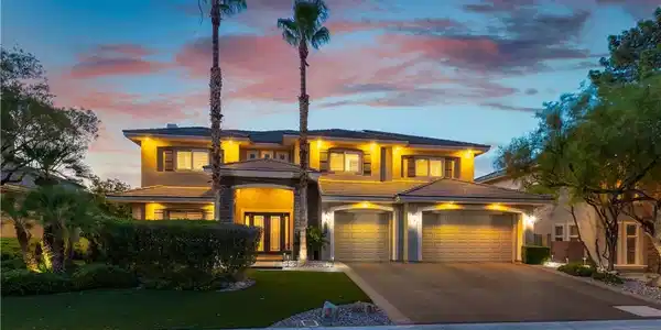 Image 4: Illuminated at dusk, this substantial residence sh