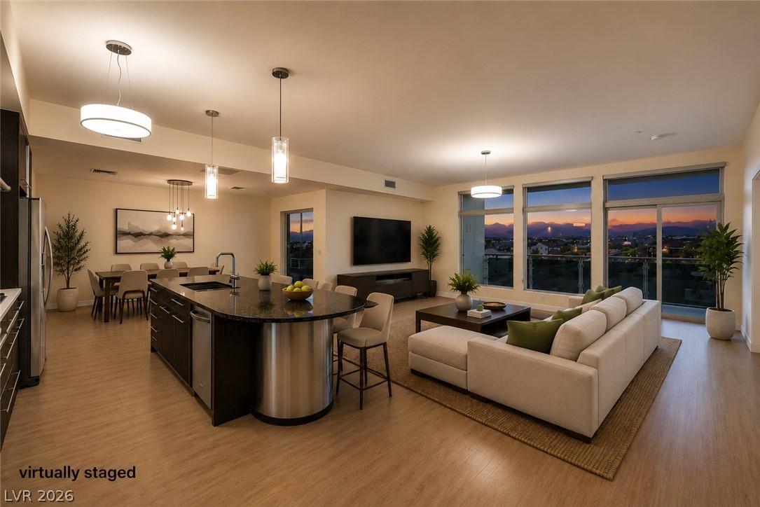 Image 3: An open-concept living area boasts a modern kitche