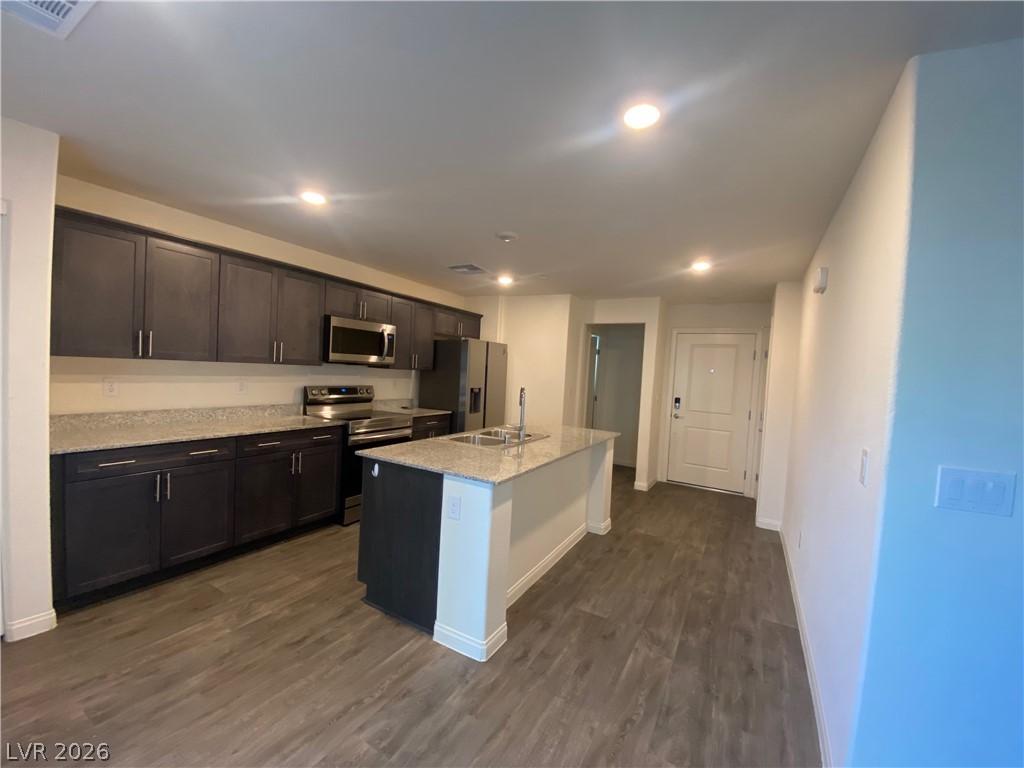 Image 3: A contemporary kitchen features dark cabinetry, gr