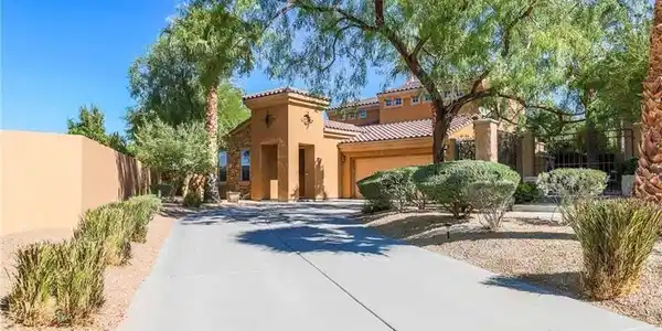 Image 2: A long paved driveway leads to this grand desert r