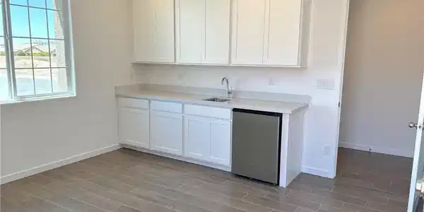 Image 4: Kitchen with dishwasher, white cabinets, wood tile