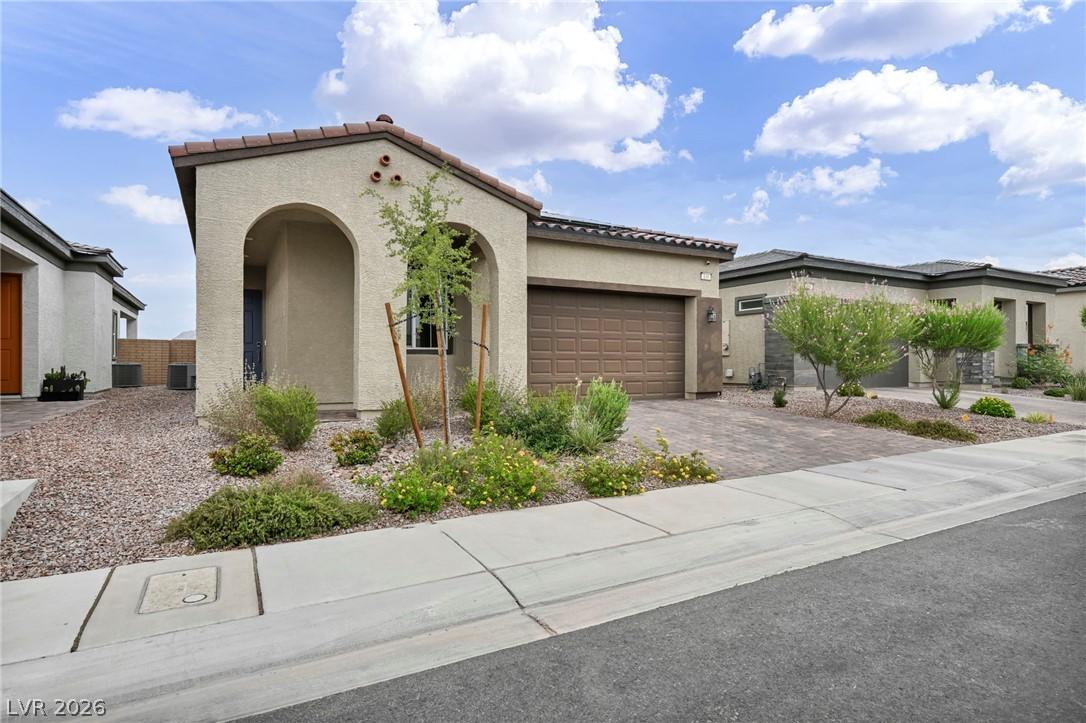 Image 4: A welcoming arched entryway and a paved driveway l