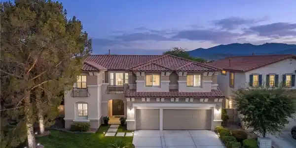 Image 2: An inviting exterior with illuminated landscaping