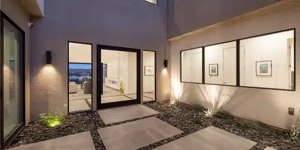 Image 4: A modern entry with geometric pavers and ambient l