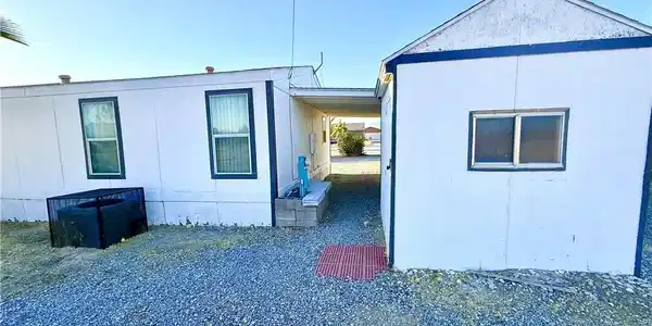Image 4: A modest home with clean lines and ample gravel sp