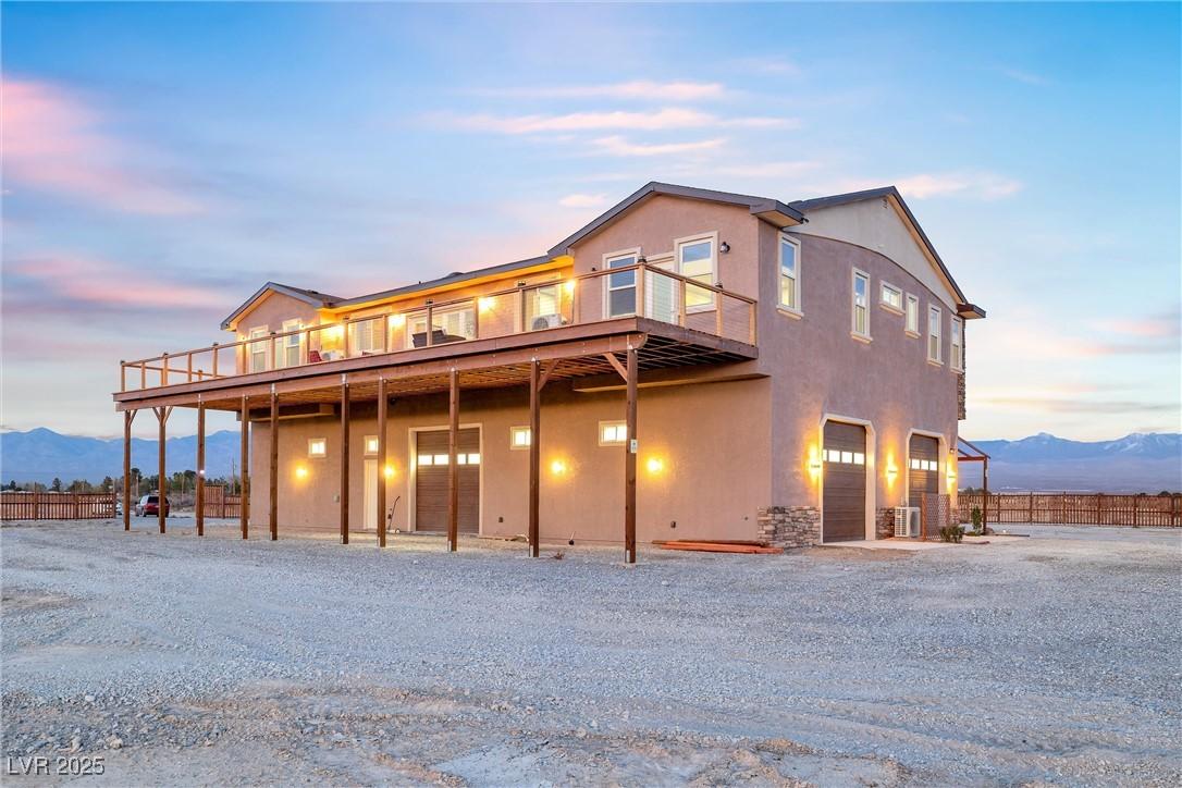 Image 2: View of front facade featuring stucco siding and a