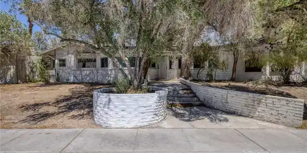 Image 2: Mature trees and brick planter walls create a priv