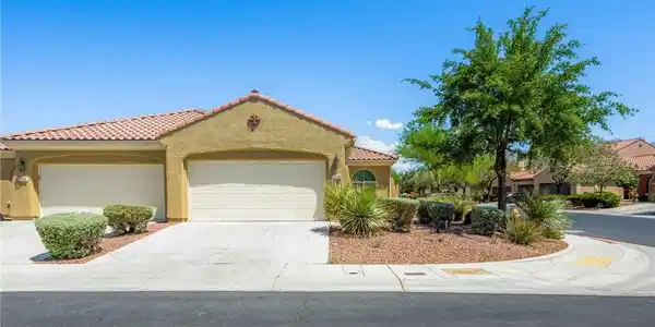 Image 2: A well-maintained stucco home with a tile roof and
