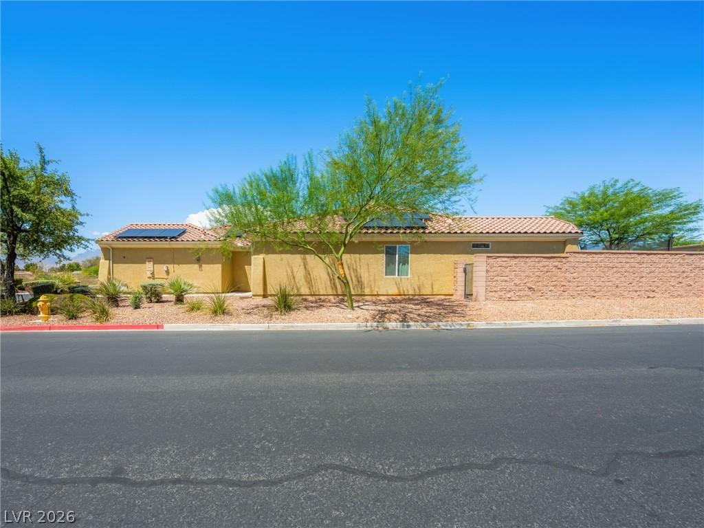 Image 4: A well-maintained stucco home with a tile roof and