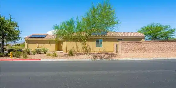 Image 4: A well-maintained stucco home with a tile roof and