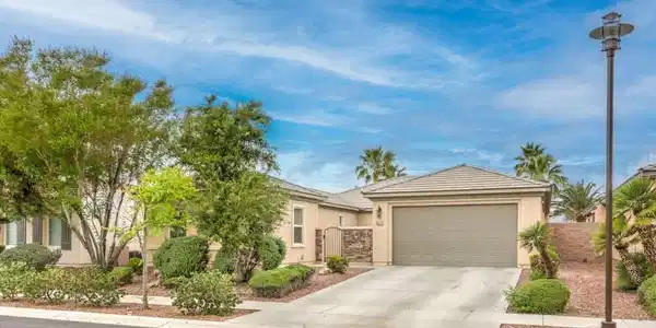 Image 3: Manicured desert landscaping frames a classic stuc