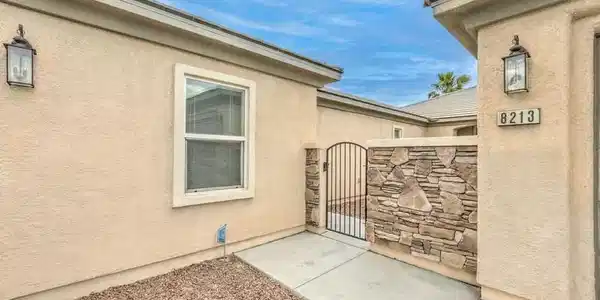Image 4: An inviting gated entrance features textured stone