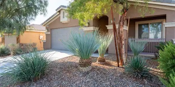 Image 4: Desert plantings accent the stucco exterior and ti