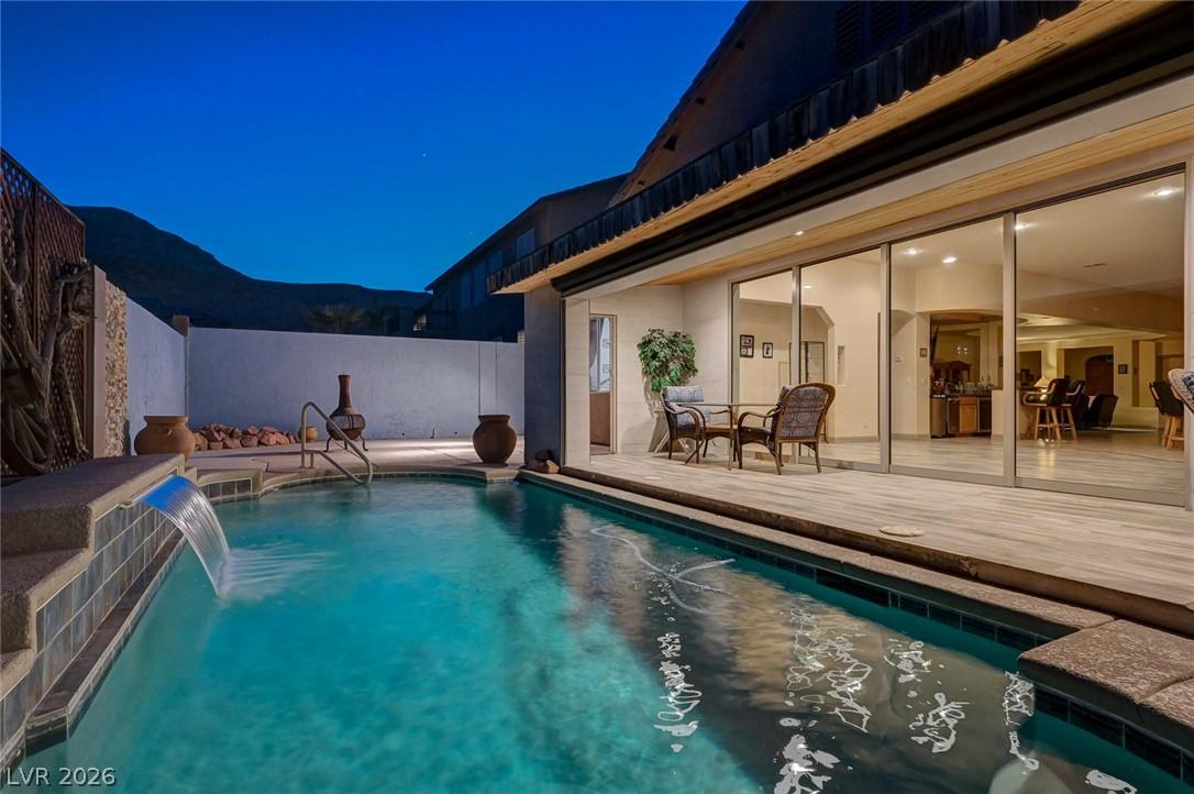 Image 1: An inviting private pool area features a waterfall