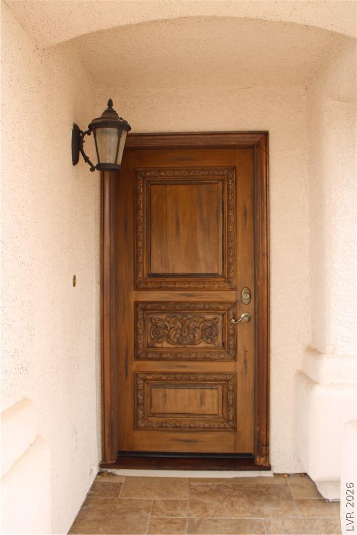Image 3: Ornately carved wooden entry door creates a striki