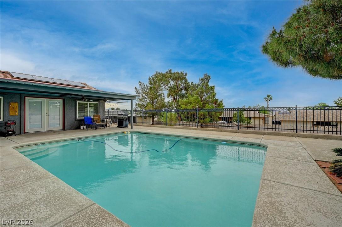 Image 4: View of pool with french doors, patio surround, an