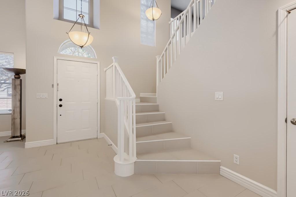 Image 4: A spacious entry features soaring ceilings, lumino