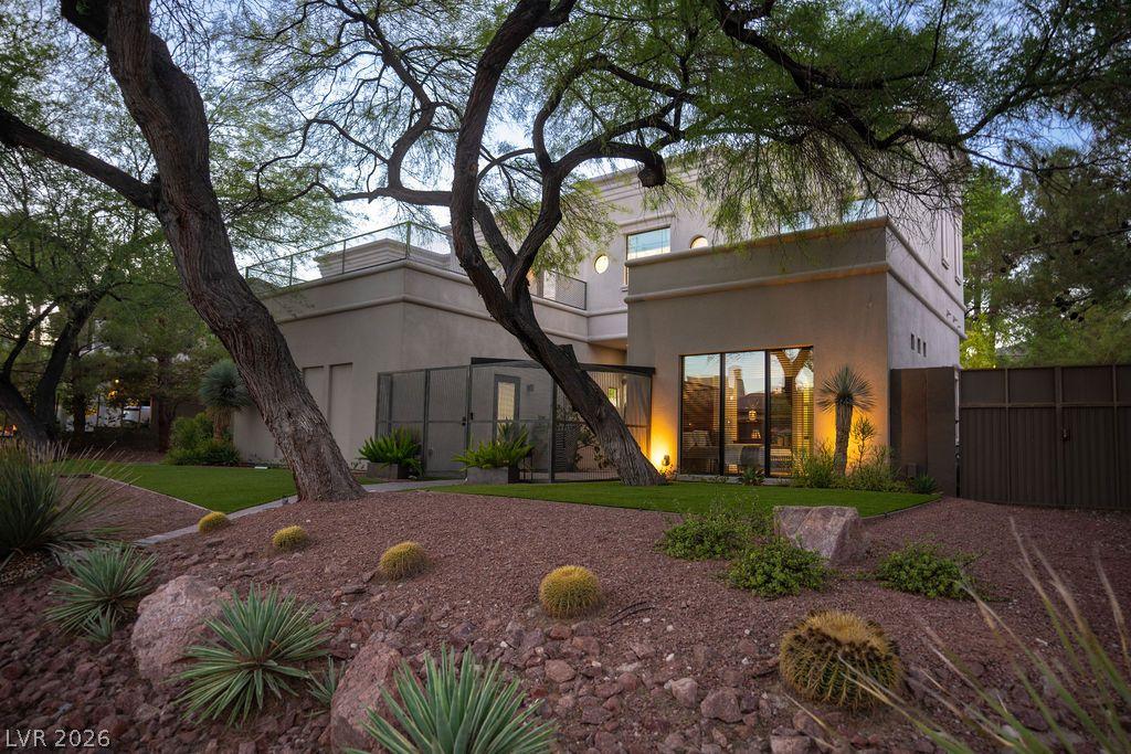 Image 1: Mature trees and desert landscaping frame this inv