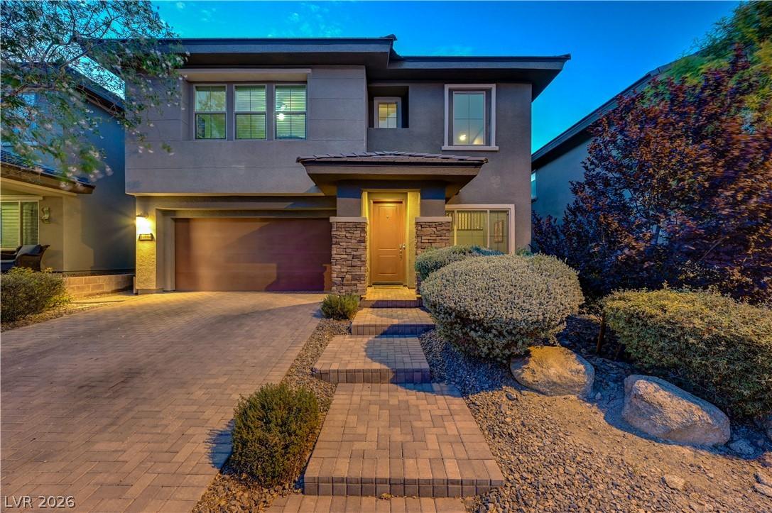 Image 1: A contemporary exterior features stone accents, a