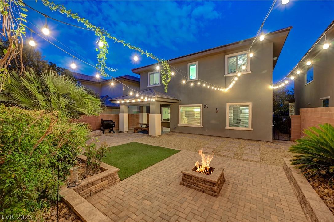 Image 2: An inviting backyard oasis offers a built-in fire