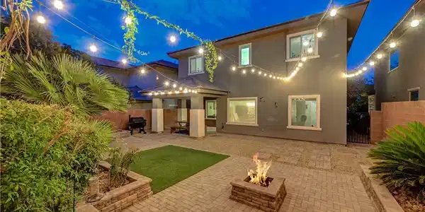 Image 2: An inviting backyard oasis offers a built-in fire