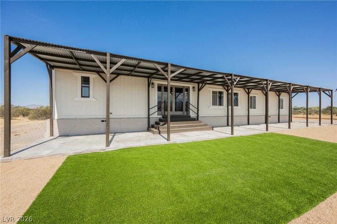 Image 2: A long, covered patio extends across the home's fa