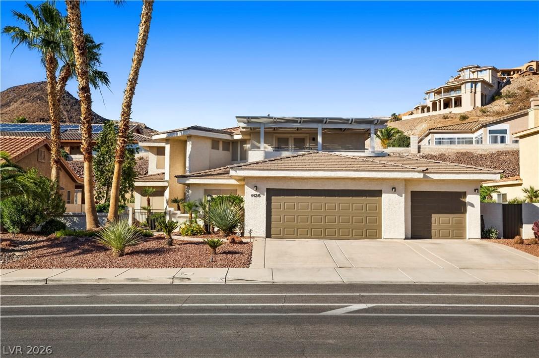 Image 2: A spacious home with desert landscaping and an inv